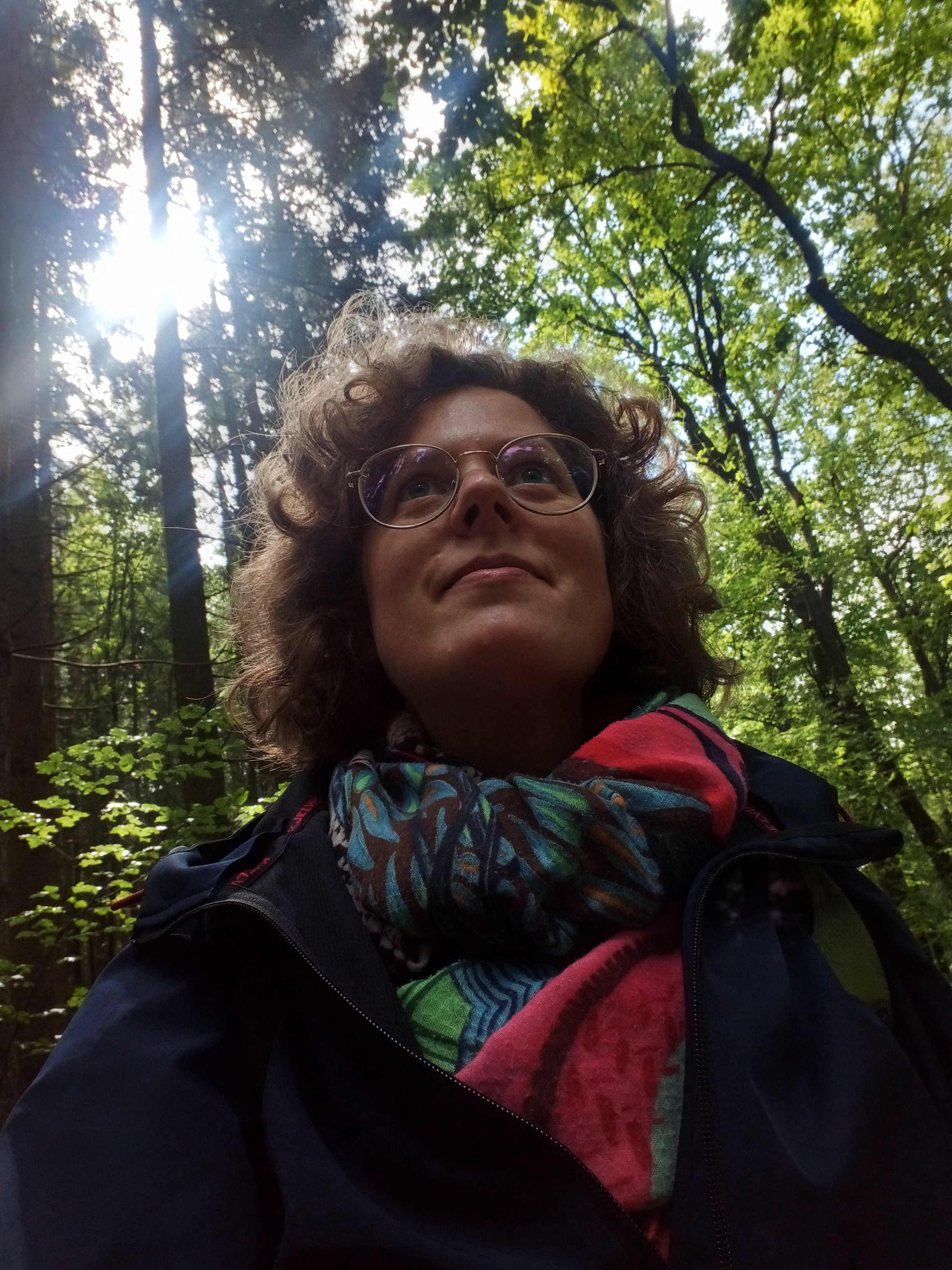 Een foto waarbij het licht valt van achteren en van boven. Ik sta in het bos, in de schaduw van het licht.