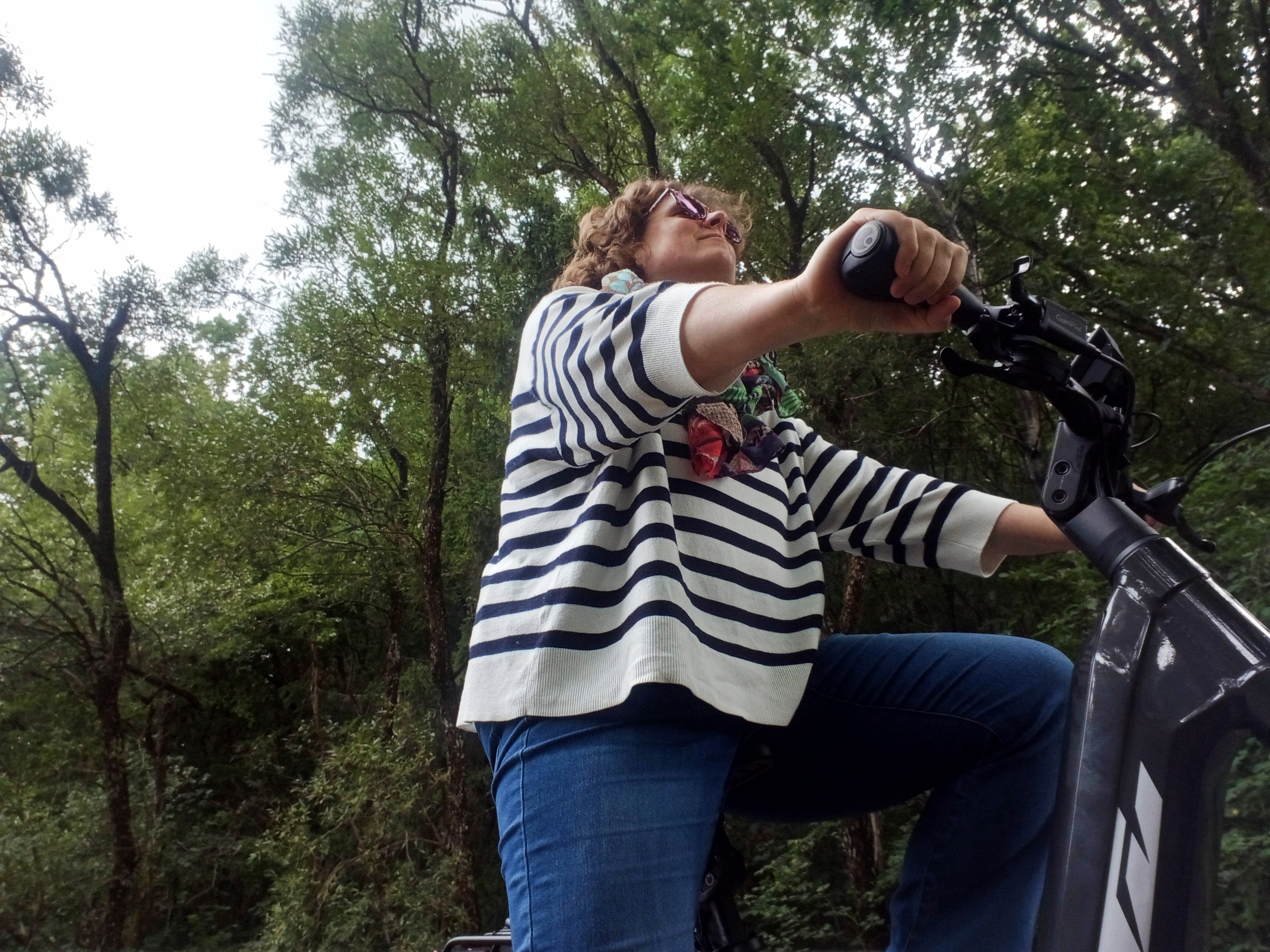 Foto van mij waarbij ik op de fiets zit en voor mij uitkijk. Achter mij de groene bossen van Alfbachtal.